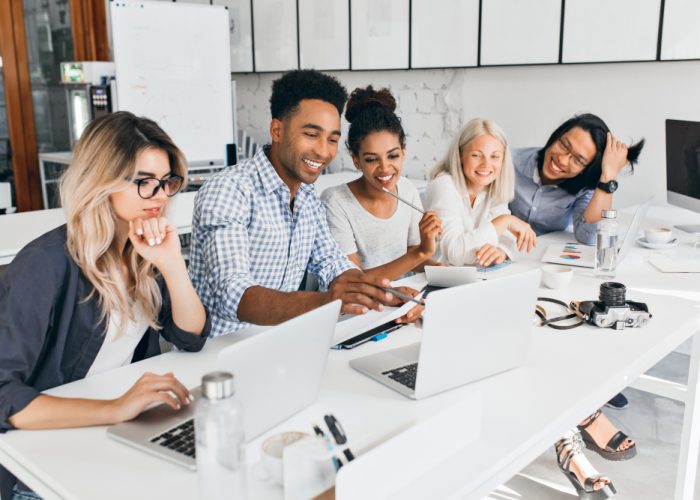 smiling-african-student-pointing-with-pencil-laptop-screen-concentrated-blonde-woman-glasses-propping-chin-with-hand-while-working-with-computer-office smiling-african-student-pointing-with-pencil-laptop-screen-concentrated-blonde-woman-glasses-propping-chin-with-hand-while-working-with-computer-office
